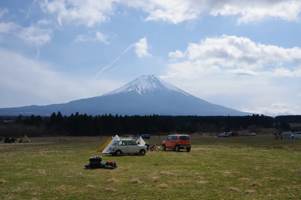 Tents and cars spread across the open field at Fumotoppara with Mount Fuji behind