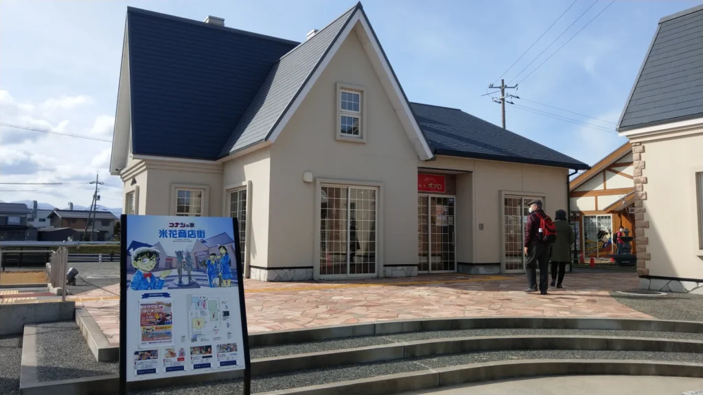 Cream-walled house with a dark pitched roof beside a paved plaza at Beika Shopping Street in Hokuei, Tottori