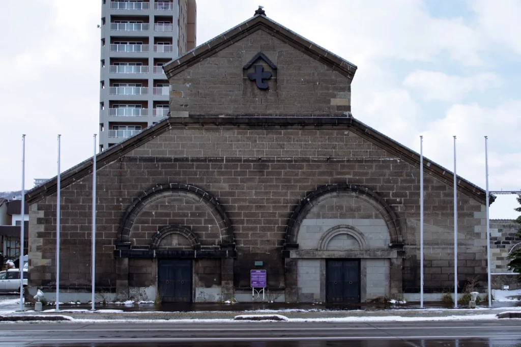 The Former Ohya Warehouse in Otaru, a stone warehouse with a double-arched doorway, after light snow