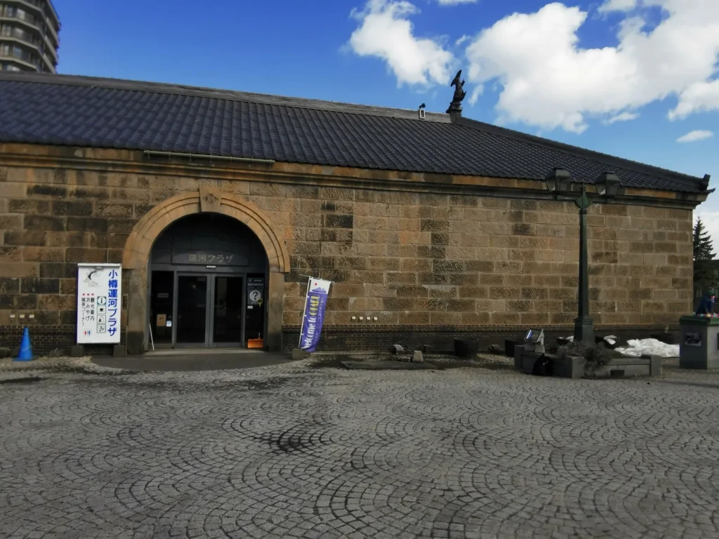 The stone front of the Former Otaru Warehouse in Otaru, with an arched doorway and a tiled roof