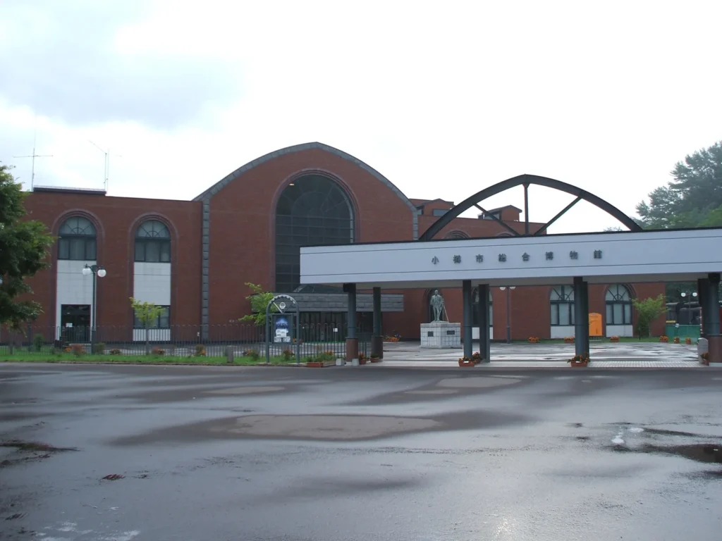 The main entrance of the Otaru Museum main building in Temiya, a red-brick hall behind a canopy and signboard