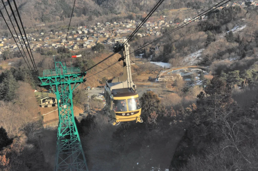 A Hodosan Ropeway cabin climbing above the trees at Nagatoro