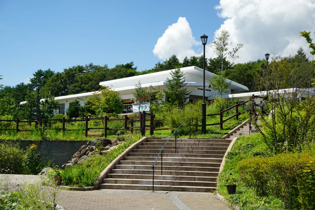 The white station building of Kiyosato Station on the Koumi Line, seen from the steps in front of it