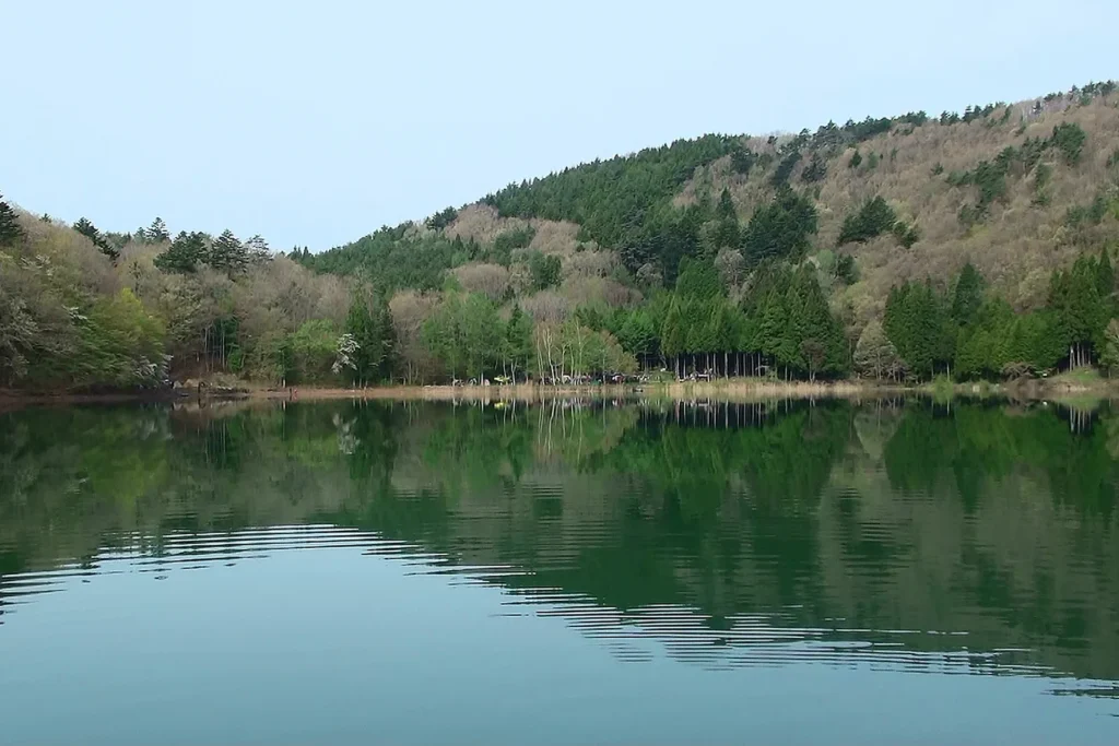 The still water of Lake Shibire ringed by wooded hills in Ichikawamisato