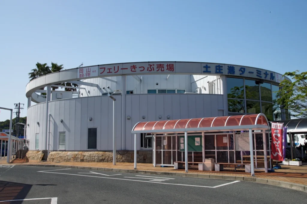 The rounded white Tonosho Port terminal building with the sign for the ferry ticket office