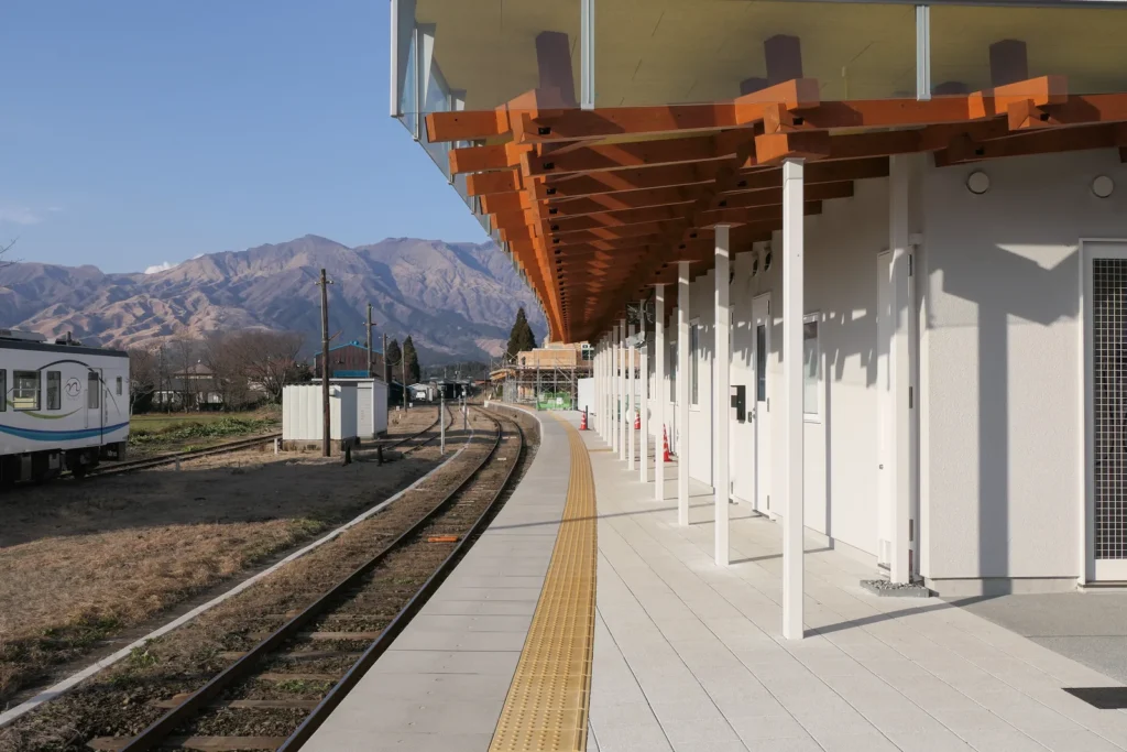 Platform at Takamori Station with a Minami Aso Railway railcar and the Aso mountains behind