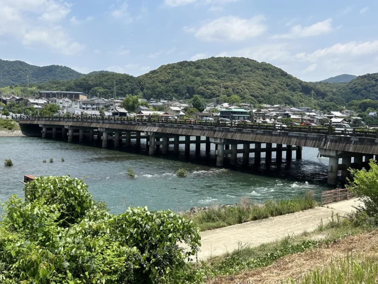 The long low Uji Bridge crossing the Uji River, with wooded hills behind it